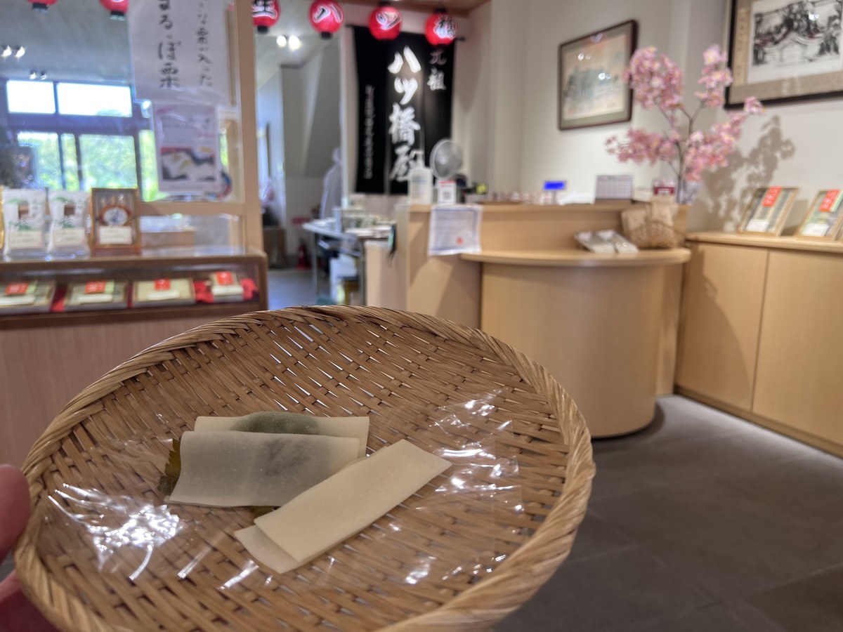 店内の竹のざるに載った試食の生八ッ橋。薄い皮ごしに餡が透けて見える
