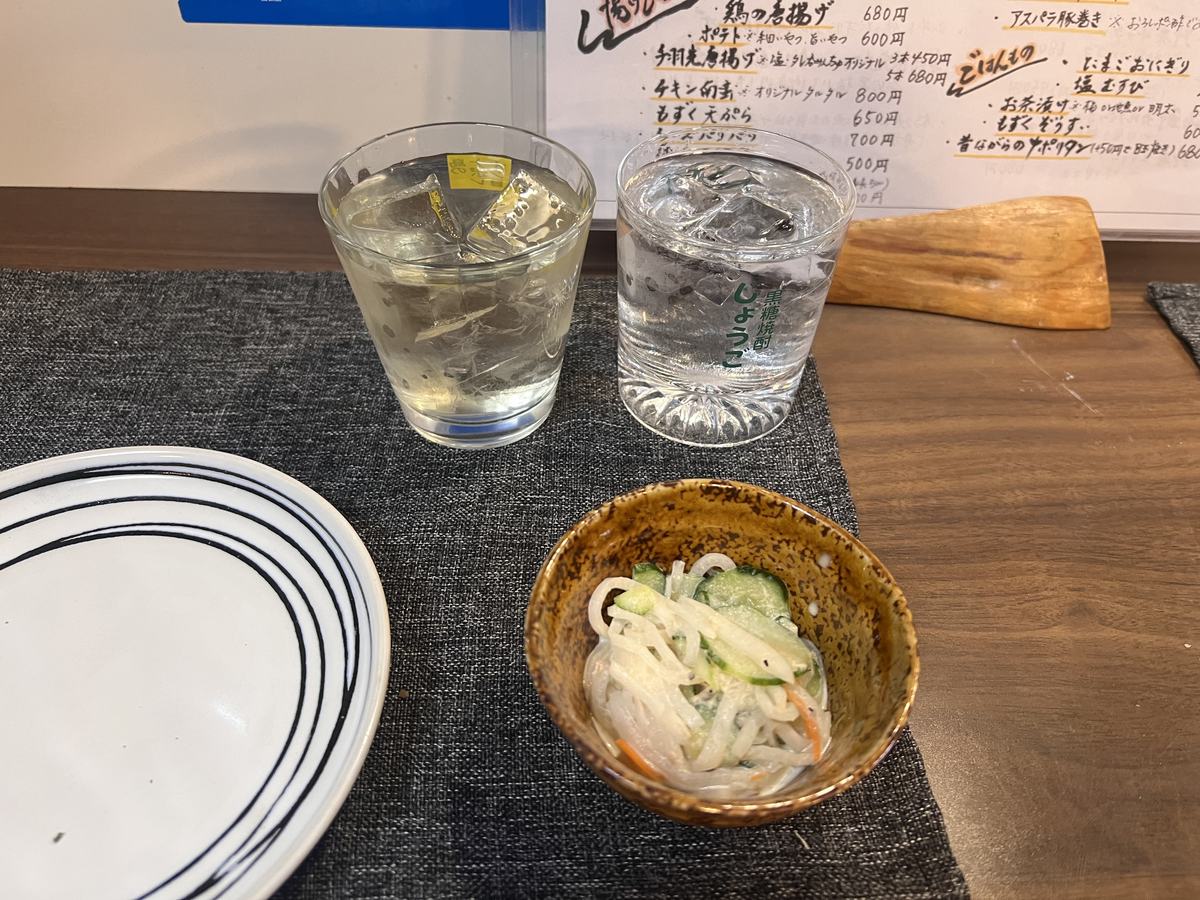 ロックグラスに並々と注がれた黒糖焼酎とお通し