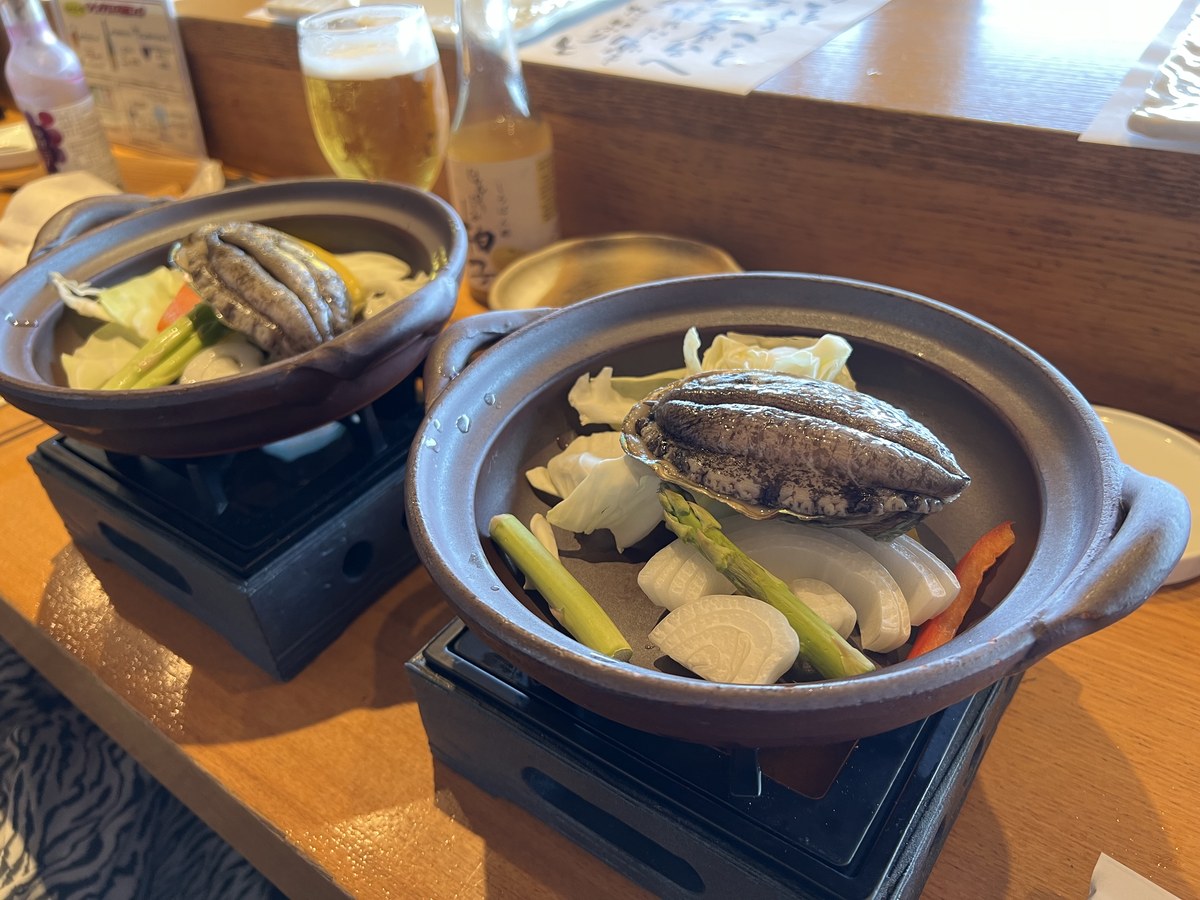 土鍋の固形燃料コンロで焼かれる鮑の踊り焼きと野菜