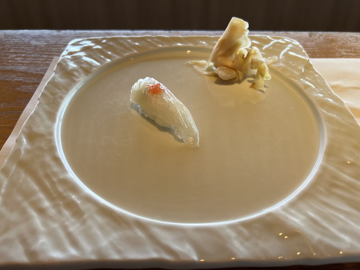 大きな白い角皿に一貫だけ置かれたヒラメの握り