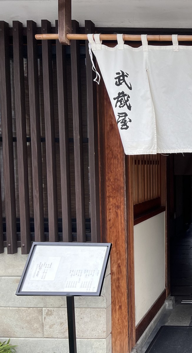 武蔵屋の白い暖簾に墨書された店名