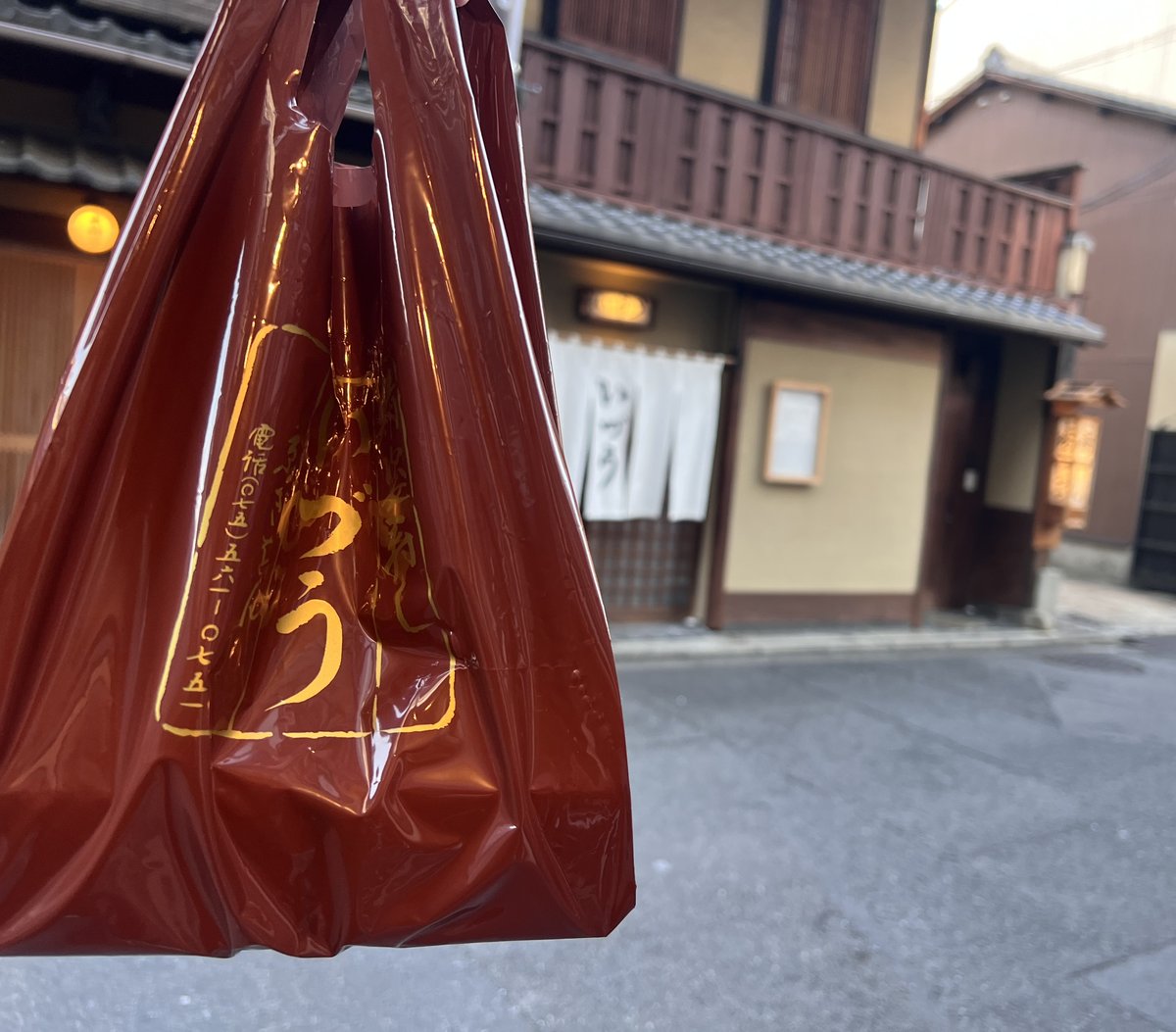 いづうの赤いビニール袋と、背景の店構え