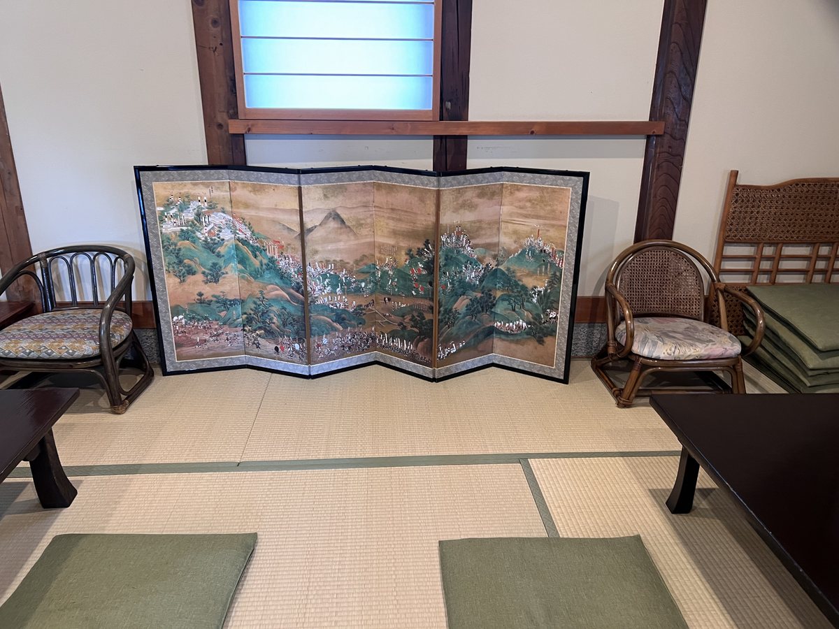 武蔵屋2階の座敷。六曲の屏風と籐の座椅子