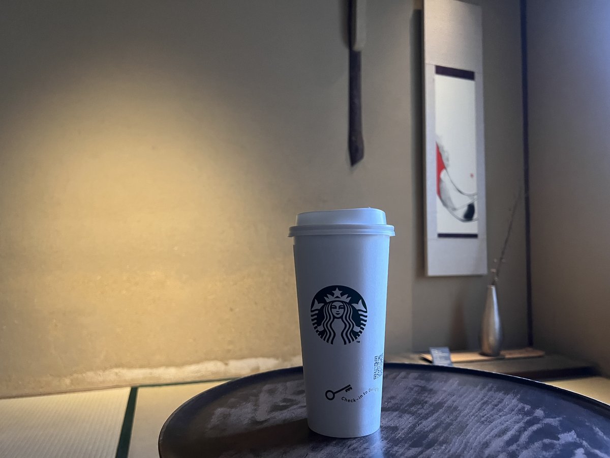 畳の間の黒い丸盆に置かれたスターバックスのカップ