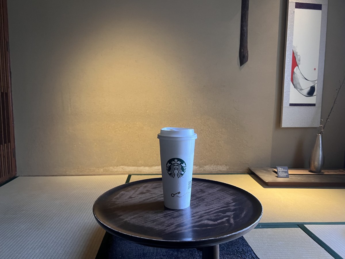 畳の間の床の間。掛け軸と一輪挿しと、盆の上のカップ