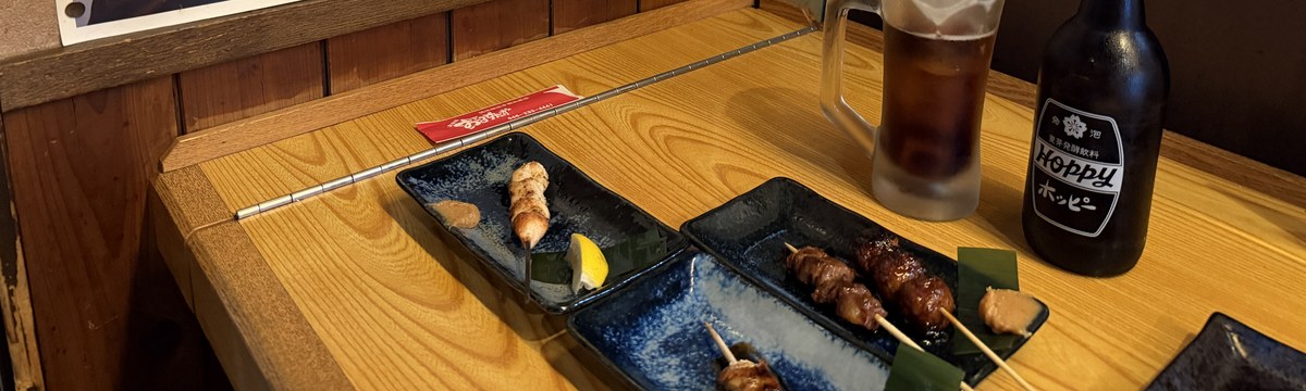 おーるすたぁずのカウンターに並んだ串の皿とホッピー